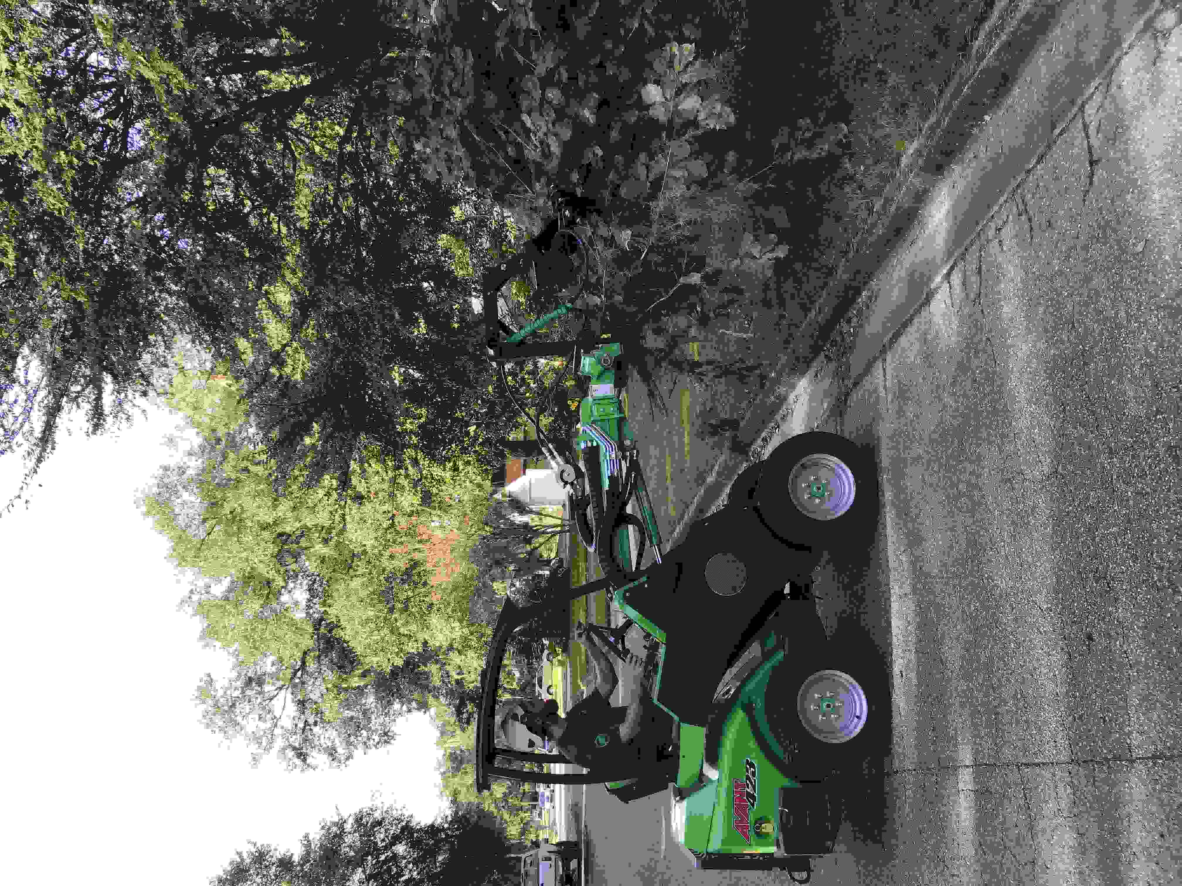 An Avant wheel loader lifting a large pile of brush off of a lawn.